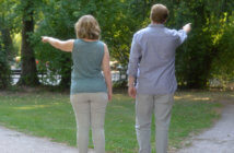 7 Ways to Lead When the Way Ahead Is Unclear Two people pointing in different directions while standing on the crossroads of a path