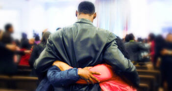 A person receiving hugs in a church sanctuary