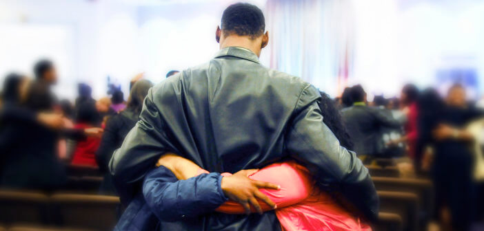 A person receiving hugs in a church sanctuary