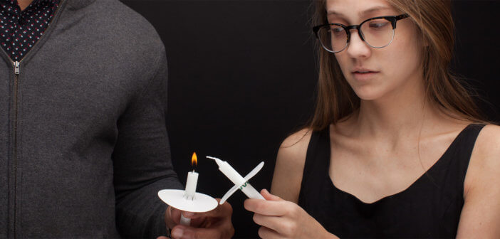 Tentative looking person passing candlelight at a Christmas Eve service