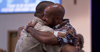 Smiling church members sharing a hug