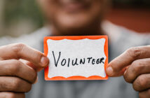 Get Off to a Great Start with Volunteers in the New Year Person holding a VOLUNTEER name tag