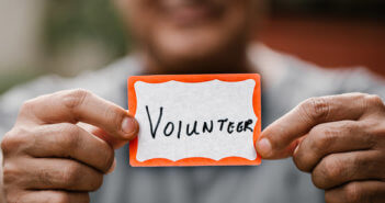 Person holding a VOLUNTEER name tag