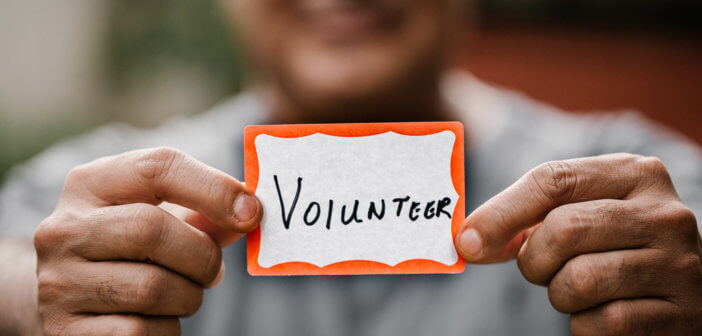 Person holding a VOLUNTEER name tag