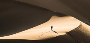 Person walking alone in a vast desert