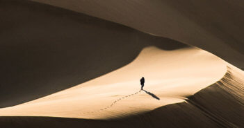 Person walking alone in a vast desert