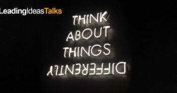Neon sign reading THINK ABOUT THINGS DIFFERENTLY with differently spelled upside down