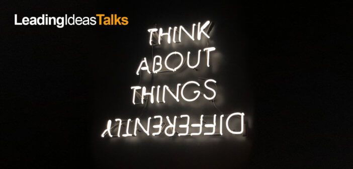 Neon sign reading THINK ABOUT THINGS DIFFERENTLY with differently spelled upside down