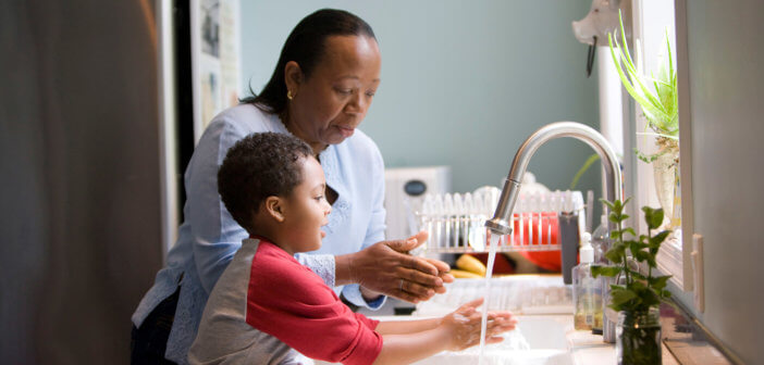 Adult teaching a child the proper way to wash their hands