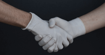 Shaking hands while wearing medical gloves