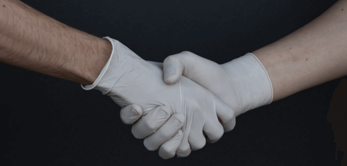 Shaking hands while wearing medical gloves