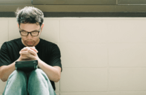 Why the Church’s Mission Really Matters in this Time of Crisis Person praying with bowed head and closed eyes in a corridor