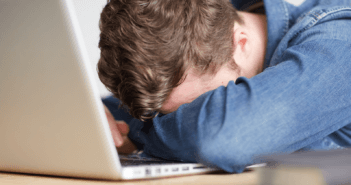 Person with their head down on their computer keyboard