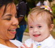 Parent holding smiling child with special needs