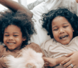 Children and parents laughing together in bed