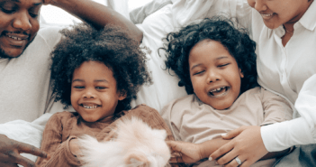 Children and parents laughing together in bed