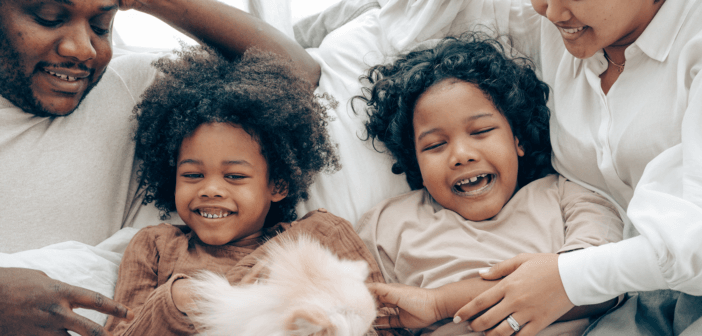 Children and parents laughing together in bed