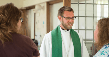 Smiling pastor chatting with church members