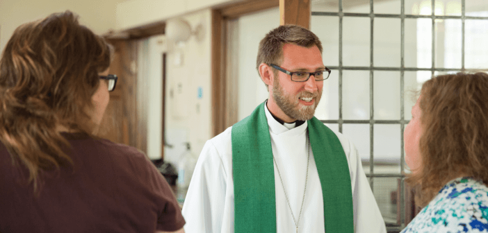 Smiling pastor chatting with church members