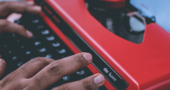 Hands typing on a typewriter