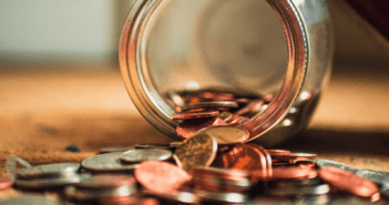 Coins spilling out of a glass jar