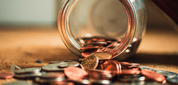 Coins spilling out of a glass jar