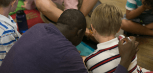 Adult with their arm around a child during a children's ministry