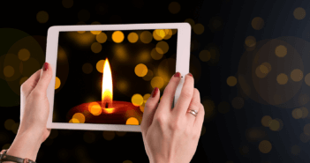 Christmas candle on the screen of a tablet computer