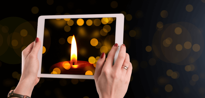 Christmas candle on the screen of a tablet computer