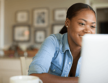 Person smiling while looking at a computer screen