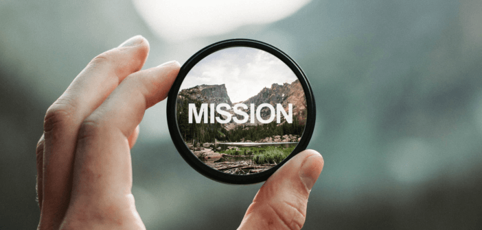 Photographer's loupe bringing into sharp focus a distant mountain range and the word MISSION