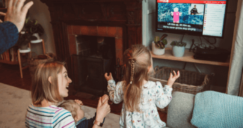 Family clapping and interacting with online worship from their living room