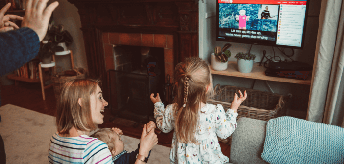 Family clapping and interacting with online worship from their living room