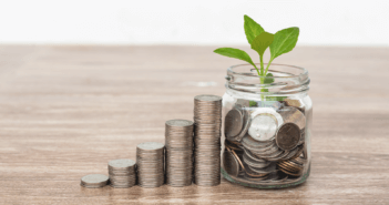 Stacks of coins increasing in height and a seedling growing from a small vase filled with coins