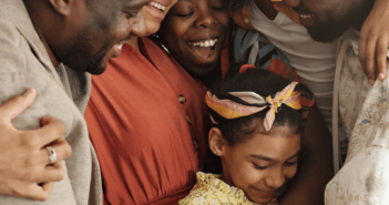 Group of people of different ages smiling and embracing at church