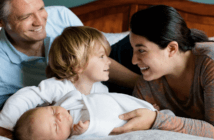 How Parents Help Children Grow in Faith Smiling parents introducing their young smiling child to their infant