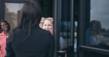 Person being warmly welcomed through a church's front doors by church memebers