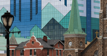 Old stone church in front of a glass skyscraper