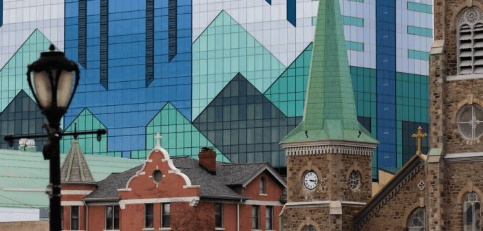 Old stone church in front of a glass skyscraper