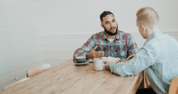 Two people having a conversation at a coffee shop