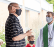 Masked pastor and church member chatting outside after church