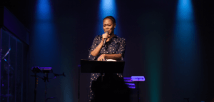 Pastor alone in the spotlight on stage