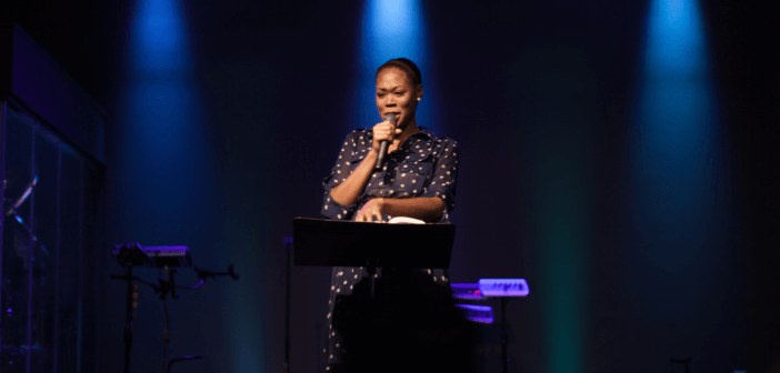 Pastor alone in the spotlight on stage