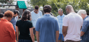 Group of people praying outdoors at a retreat