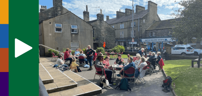 People in conversation sitting around tables set up outside of the church