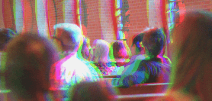 Distorted and out-of-focus image of a congregation sitting in pews