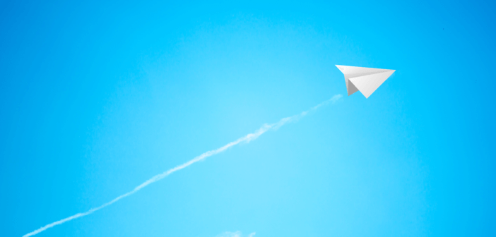 Paper airplane soaring into the sky