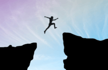 A person courageously leaping over a large chasm