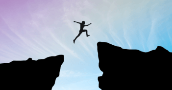 A person courageously leaping over a large chasm