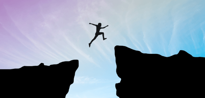 A person courageously leaping over a large chasm